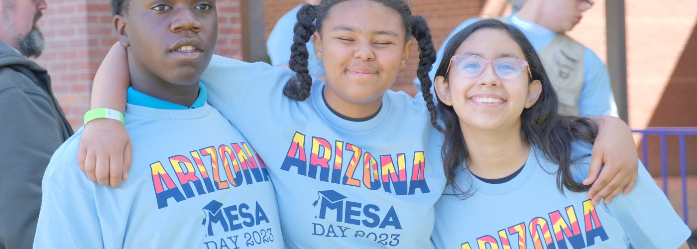 Three students wearing the light blue MESA Day 2023 t-shirt posing for a picture