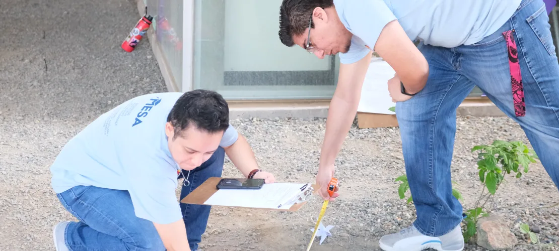 MESA volunteers measuring distance of a paper helicopter to the center of the target.